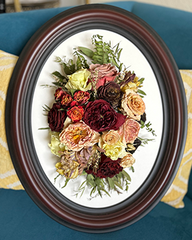 Oval wood frame with multi colored flowers