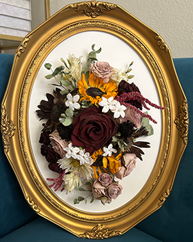 Oval gold frame with multi-colored flowers